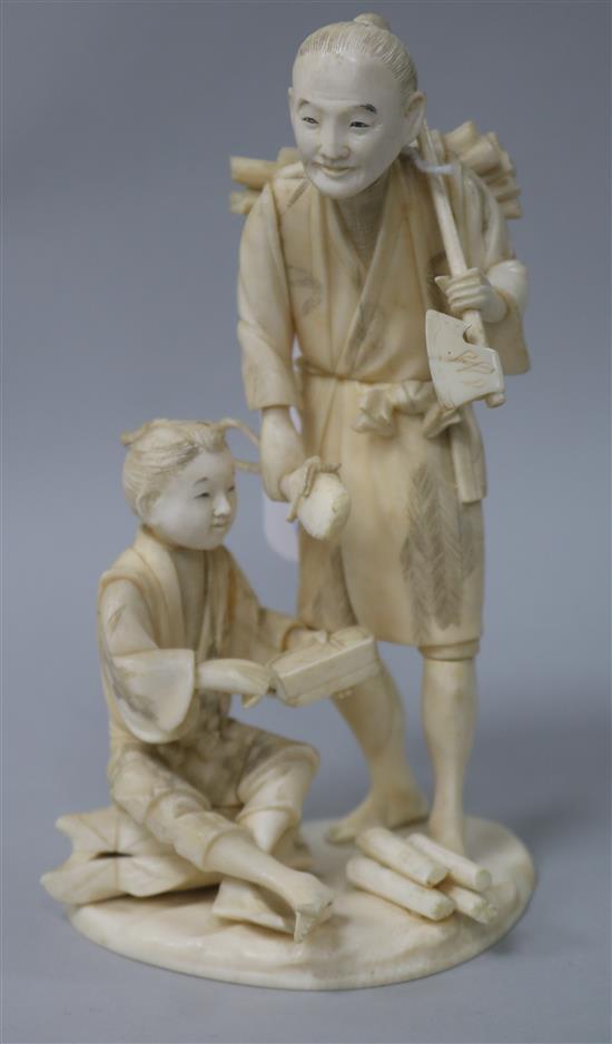 A Japanese ivory group of a woodsman holding an axe H.16.5cm